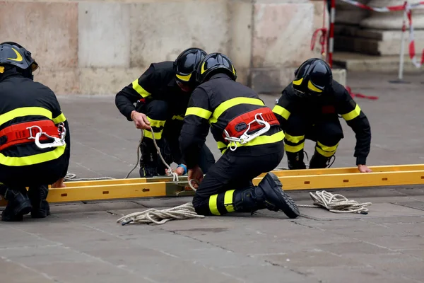 Vigili del fuoco con scala per raggiungere i piani superiori della costruzione — Foto Stock