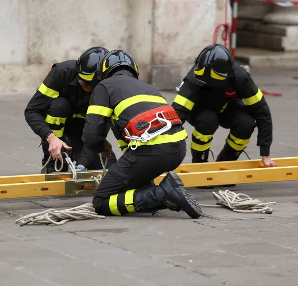 Brandmän under räddningsinsatser med trä stege — Stockfoto