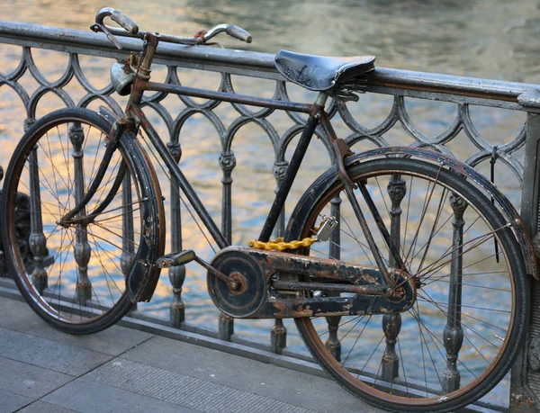 川の上の橋の上に傾いている黒の古い自転車 — ストック写真