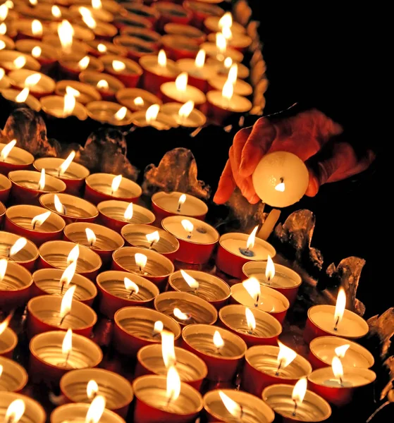 Velas encendidas en la iglesia y la mano de la anciana —  Fotos de Stock