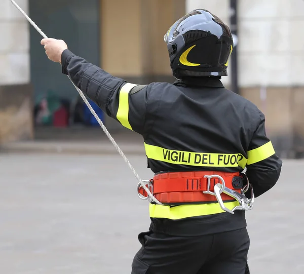 Italian firefighter with protective helmet and a rope and the wo