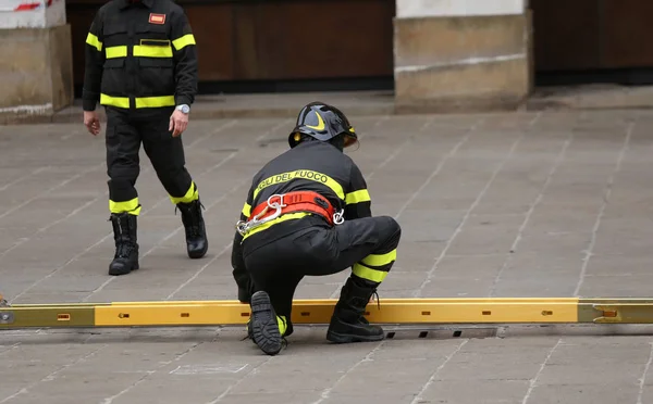 Italian firefighters during outdoor exercise with a ladder with — Stock Photo, Image