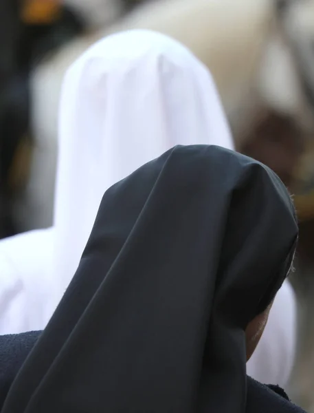 Systrar med svart och vit slöja under den heliga mässan i kyrkan — Stockfoto