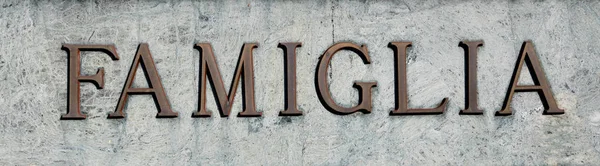 Большая надпись со словом "FAMIGLIA", что означает "СЕМЬЯ" в Италии — стоковое фото