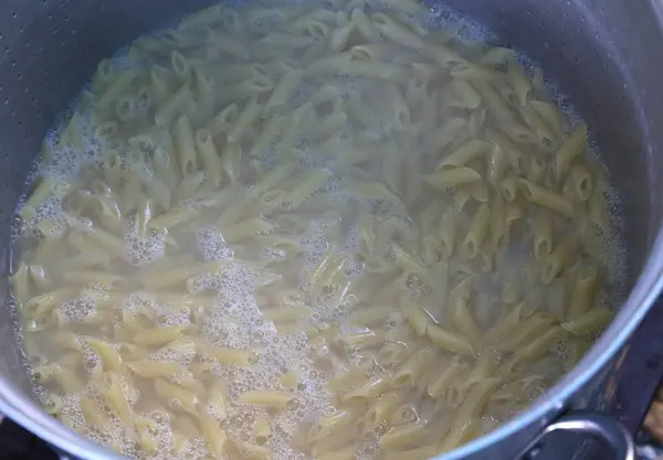 Pasta italiana cocida en el agua muy caliente en una olla grande de resta — Foto de Stock