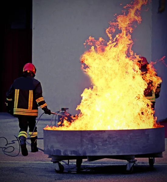 Bomberos valientes durante el ejercicio para el extintor de incendios — Foto de Stock