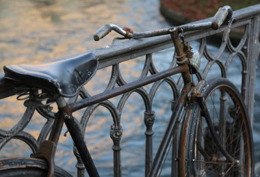 nehir üzerindeki köprüde eğilerek siyah eski bisikleti