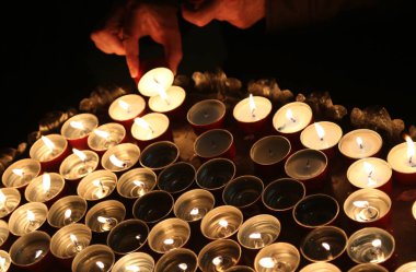 kişi bir mum dini tören sırasında ışıklar.