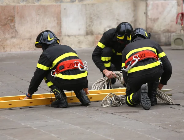 Pemadam kebakaran dengan tangga untuk mencapai lantai atas bangunan — Stok Foto