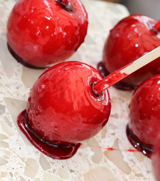 Roter Apfel mit karamellisiertem Zuckersirup und Holzstab — Stockfoto