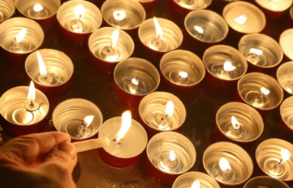 व्यक्ति धार्मिक समारोह के दौरान एक मोमबत्ती जलाता है — स्टॉक फ़ोटो, इमेज