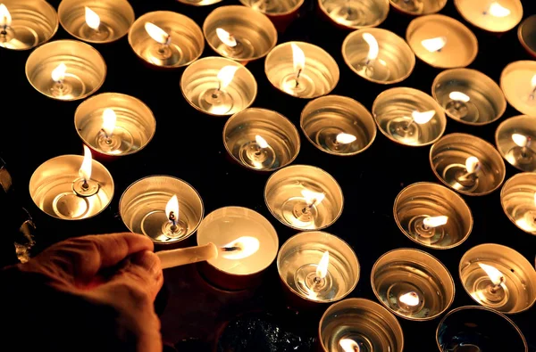 Человек зажигает свечу во время религиозной церемонии — стоковое фото