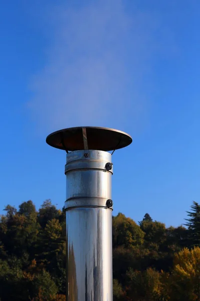 Chimenea de acero con humo contaminante que sale en un frío invierno d —  Fotos de Stock