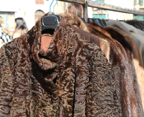 Manteaux de fourrure et vêtements à vendre dans le cintre au marché aux puces — Photo