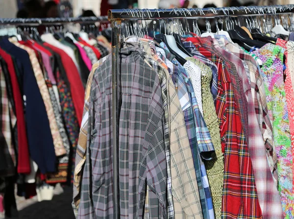 Ropa colgada de perchas para la venta en el mercado de pulgas — Foto de Stock