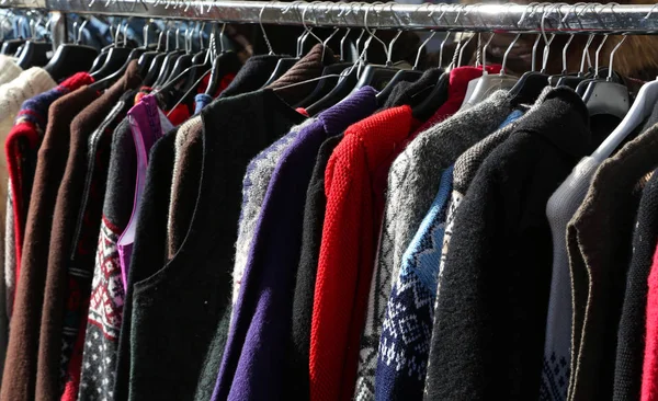 Suéteres colgando de perchas para la venta en el mercado — Foto de Stock