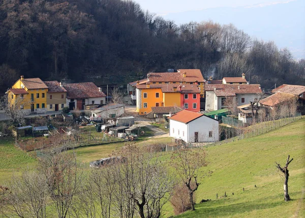 Bahar tepelerde ortasında bir kaç ev ile İtalyan Köyü — Stok fotoğraf