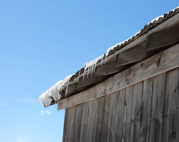 Eiszapfen auf dem Dach, die schmelzen — Stockfoto