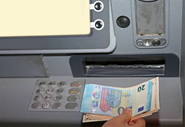 Мальчик, который снимает деньги с банкомата в банкнотах евро — стоковое фото