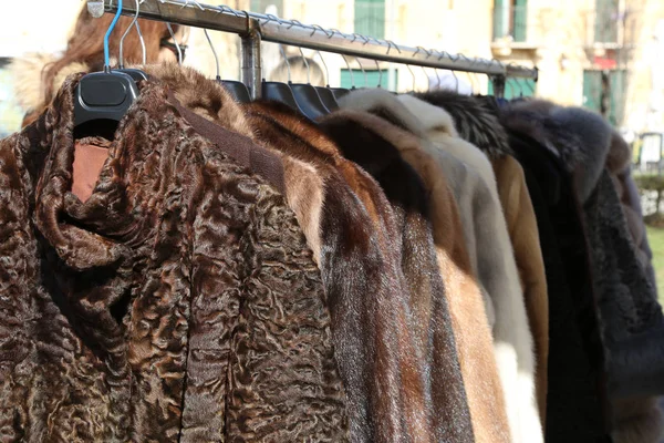 毛皮大衣和衣架在旧货市场出售的衣服 — 图库照片
