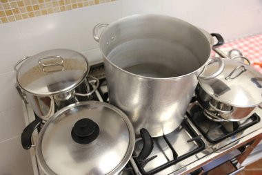 büyük endüstriyel mutfak soba üzerinde çelik kapaklı tencere