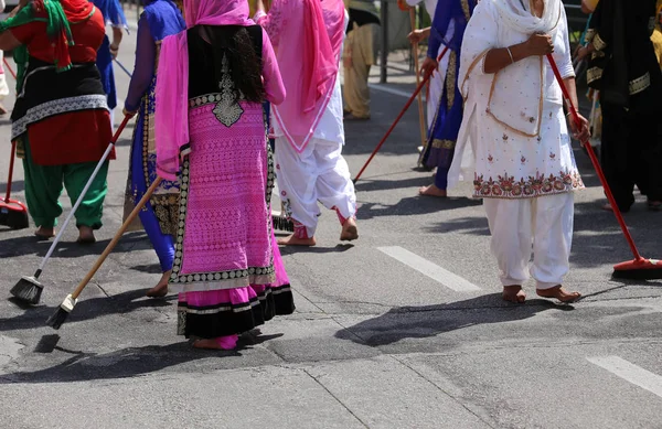 Сикхів жінок босоніж, хоча очищення дороги під час сикхів фестивалю — стокове фото