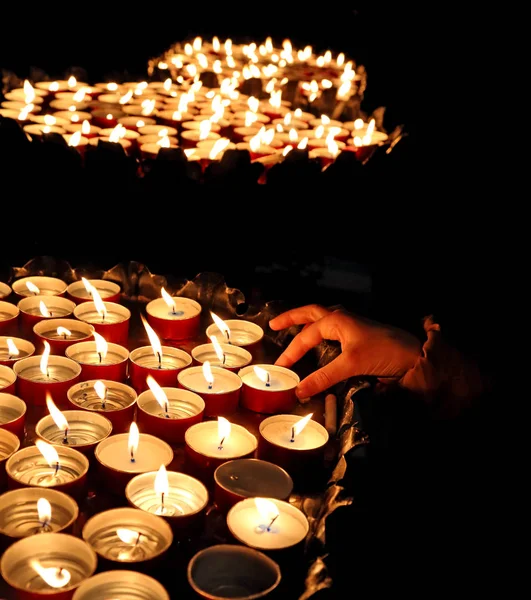 Person zündet während der religiösen Zeremonie eine Kerze an — Stockfoto