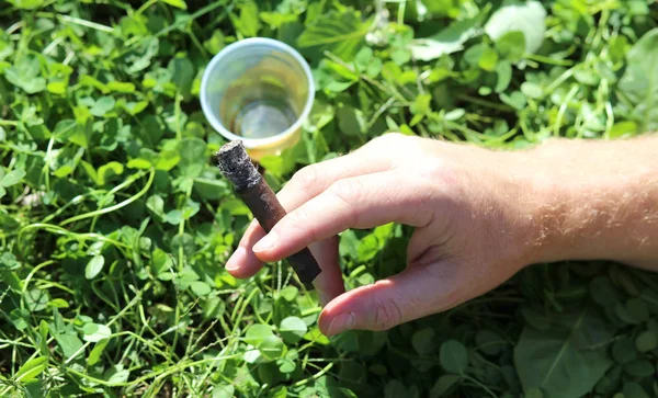 Kettenraucher mit Zigarre in der Hand und einem Glas Schnaps — Stockfoto