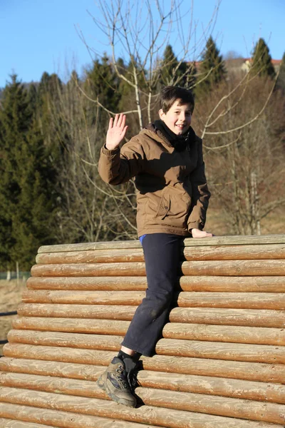 Niño juega en la casa de un parque infantil de montaña en invierno —  Fotos de Stock