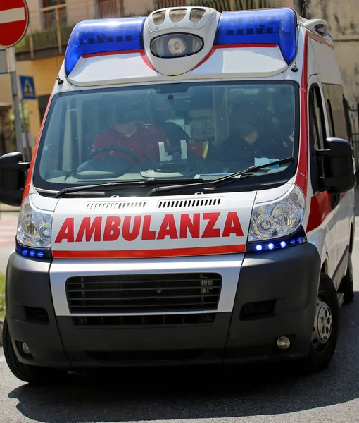 Ambulance on the city road during an emergency with blue sirens — Stock Photo, Image