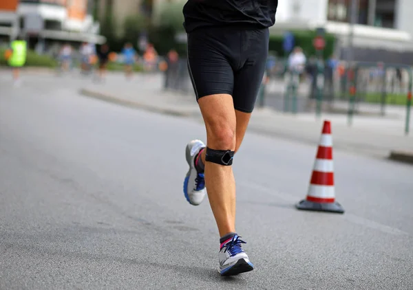 Idrottsman körs med bandage på sina knän under maraton — Stockfoto