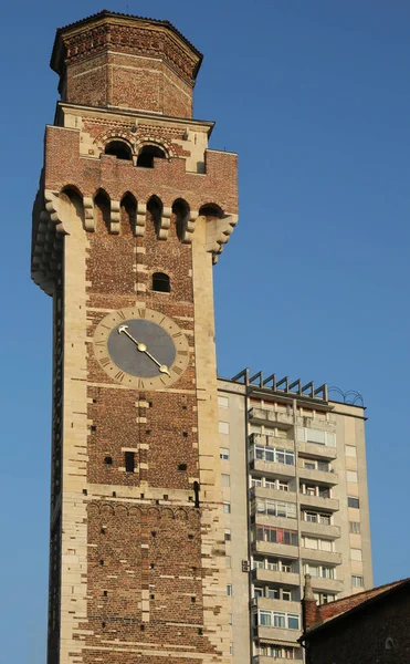 Old bell tower with clock of an ancient Italian basilica and the — Stock Photo, Image