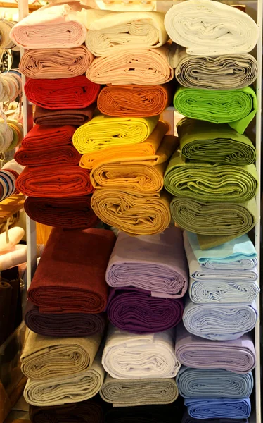 Shelf with several rolls of colored fabric for tailors — Stock Photo, Image