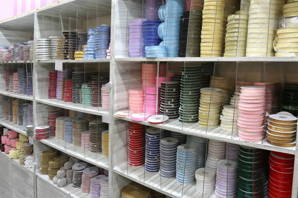 Estante lleno de cintas para la venta en la tienda de mercería — Foto de Stock