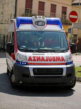 Ambulance on the city road during an emergency with blue sirens clipart