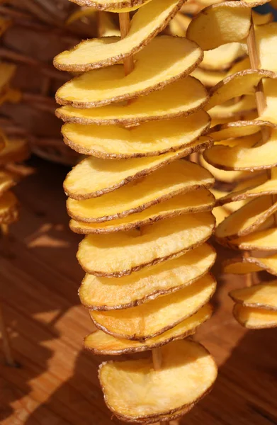 Batatas fritas fatiadas preso no espeto de madeira na rua — Fotografia de Stock