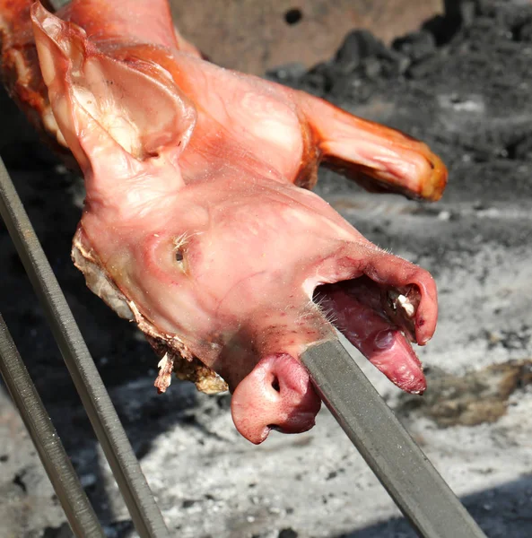 Suckling pig spit while it is being cooked — Stock Photo, Image