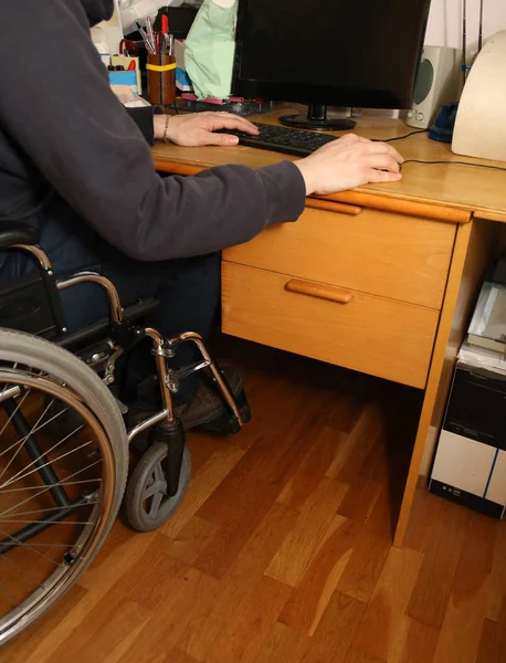 Jonge man in een rolstoel met behulp van de computer op de des uitgeschakeld — Stockfoto