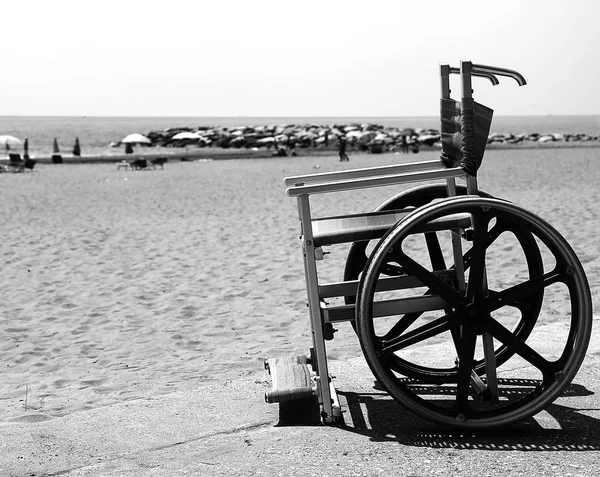 Rullstol med rostfria hjul på stranden med svart och whit — Stockfoto