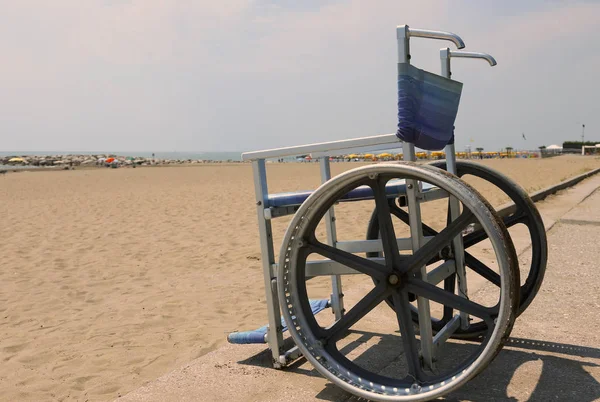 Silla de ruedas con grandes ruedas de acero para cruzar la playa de arena e ir —  Fotos de Stock