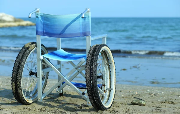 Fauteuil roulant au bord de la mer en été avec de grandes roues — Photo