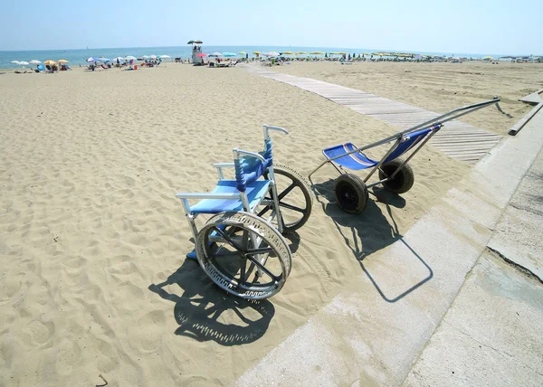 Sillas de ruedas especiales para ir en la playa de arena al mar —  Fotos de Stock