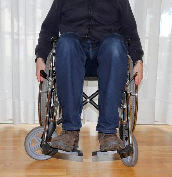 Garçon handicapé avec pantalon en jeans dans un fauteuil roulant — Photo