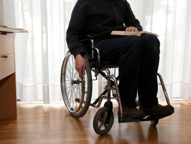 bir kitap okuma tekerlekli sandalyede yaşlı kişi