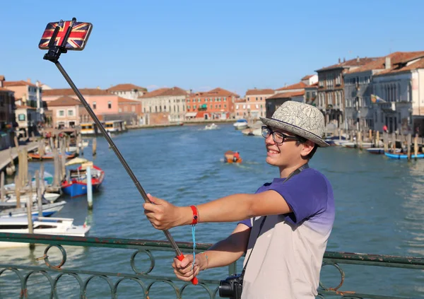 Jeune adolescent prend une photo par son smartphone sur le pont — Photo