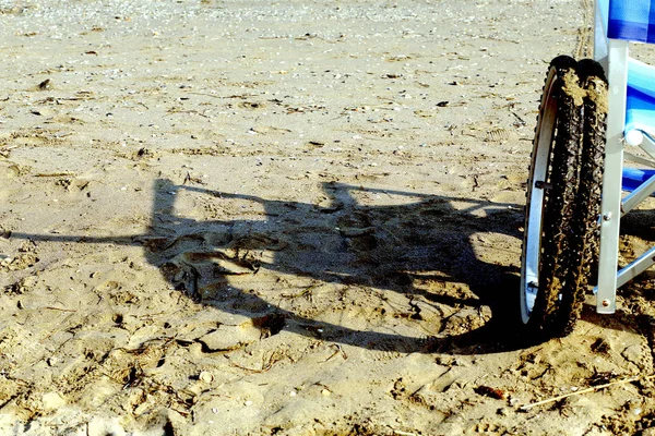 Тень инвалидной коляски на песчаном пляже — стоковое фото