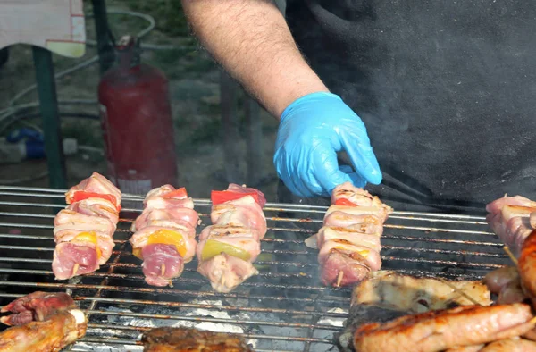 Bucătar cu mănuși albastre gătit frigărui de carne cu ardei — Fotografie, imagine de stoc