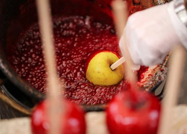 Cocine la mano con el guante y la manzana roja con azúcar caramelizada — Foto de Stock