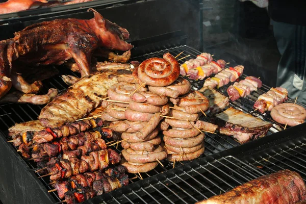 Gekochtes Fleisch mit Wurst und Schweinespießen auf dem Grill — Stockfoto