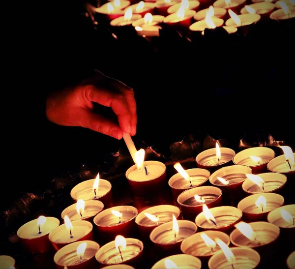 Mulher que acende uma vela durante a Santa Missa no cristão — Fotografia de Stock